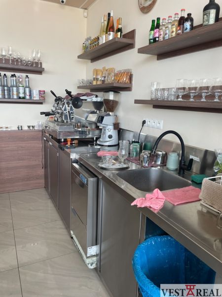 Kitchen space with bar equipment and drinks, floor with wooden decor.