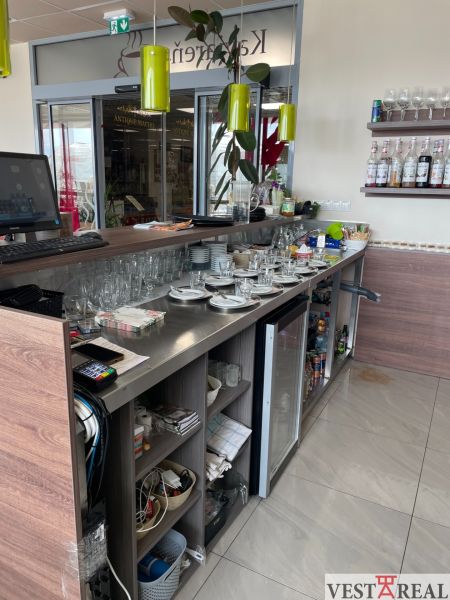 A bar counter with drinks and dishes in a gastro space with a wooden decor floor.