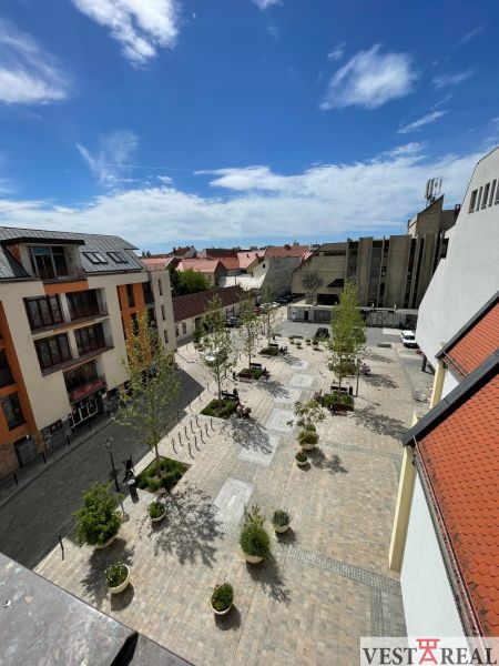 View of the Trinity Square in Trnava, with dining spaces and greenery.