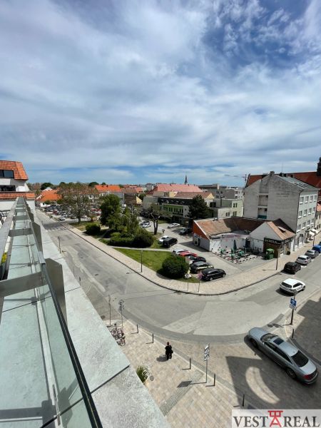 View from the Trinity Square in Trnava towards the parking lot and surrounding buildings.