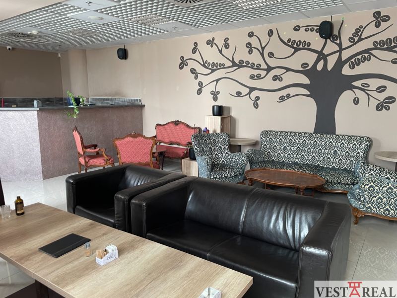 Gastro premises with leather armchairs, patterned sofas, and wall decorations.