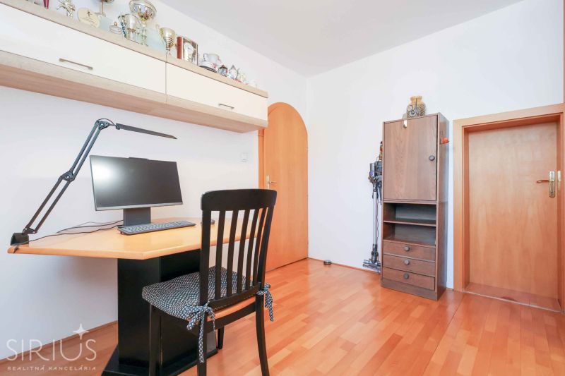 A workspace with a computer and a wooden decor floor in a family house.