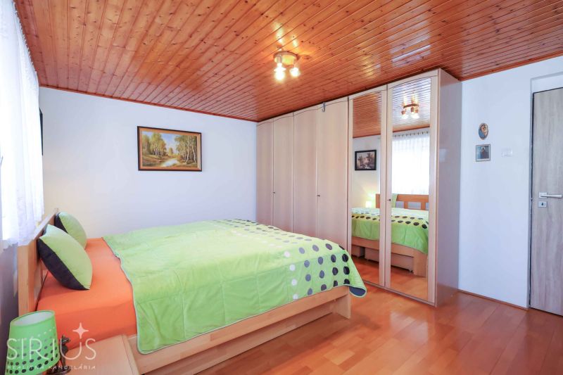 Bedroom in a family house with wood-patterned flooring and a built-in wardrobe.