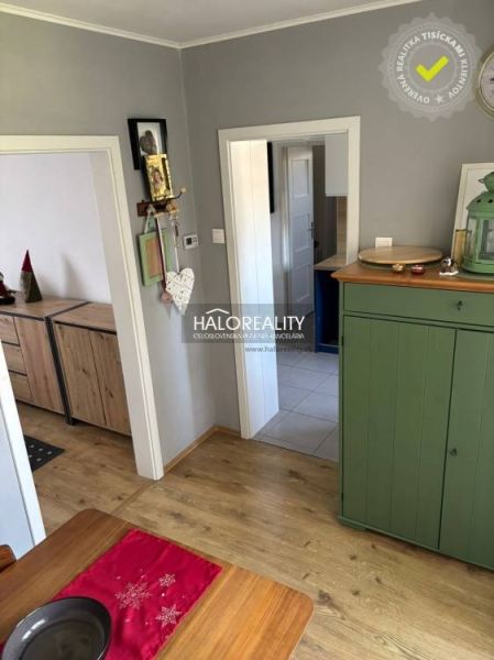 Interior of a family house with a wooden decor floor, a green dresser, and decorations.
