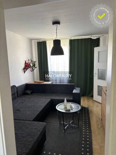 Living room in a family house with a black couch and a wooden decor floor.