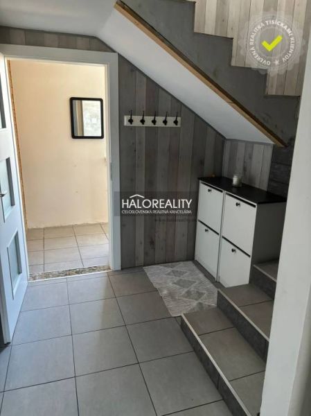 Interior of a family house with stairs, a cabinet, and a coat rack, floor with wooden decor.