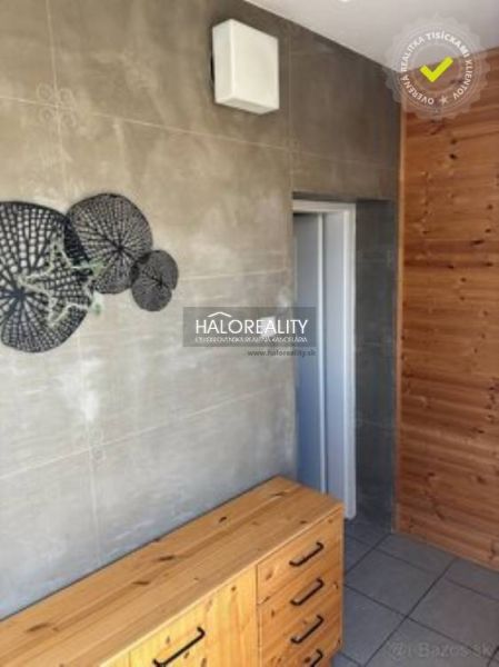Interior with a wooden wall, tiles, and a decorative element in a family house.