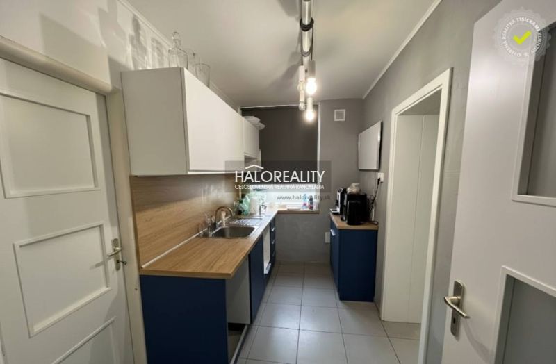 A kitchen in a family house with a wooden decor countertop and light cabinets.