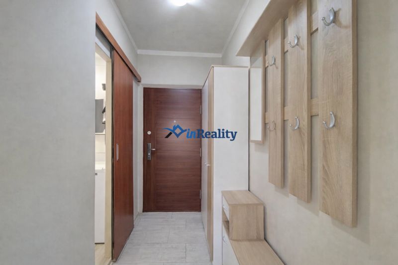 Entrance hallway with wooden decor, shoe cabinets, and coat racks in a studio apartment.