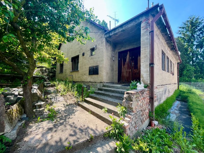 A family house in the Old Town on Búdková Street surrounded by greenery and trees.