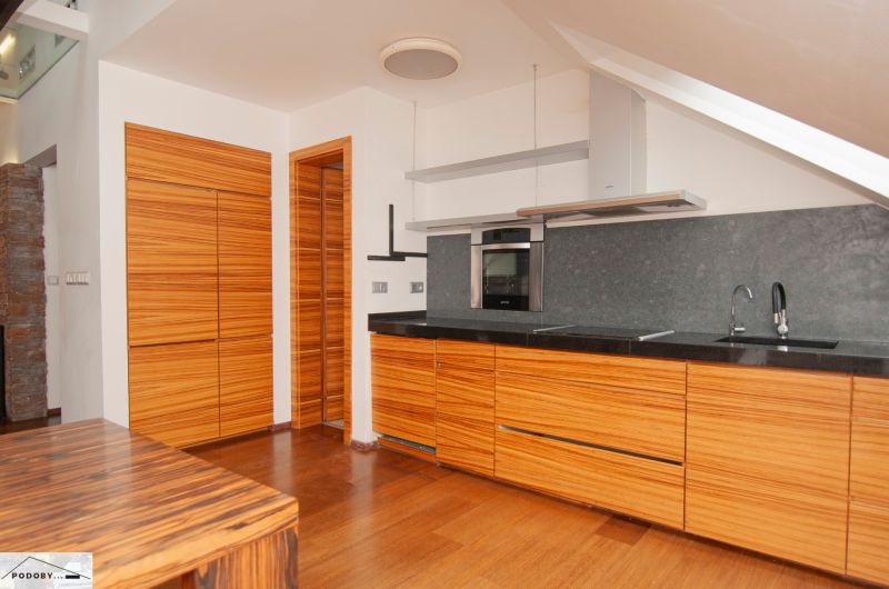 A kitchen in a 3-room apartment with a kitchen unit and a floor with a wooden decor.