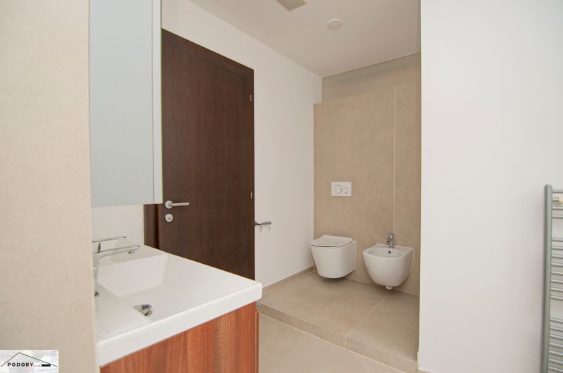 Bathroom with a shower, sink, toilet, and bidet in a 3-room apartment.