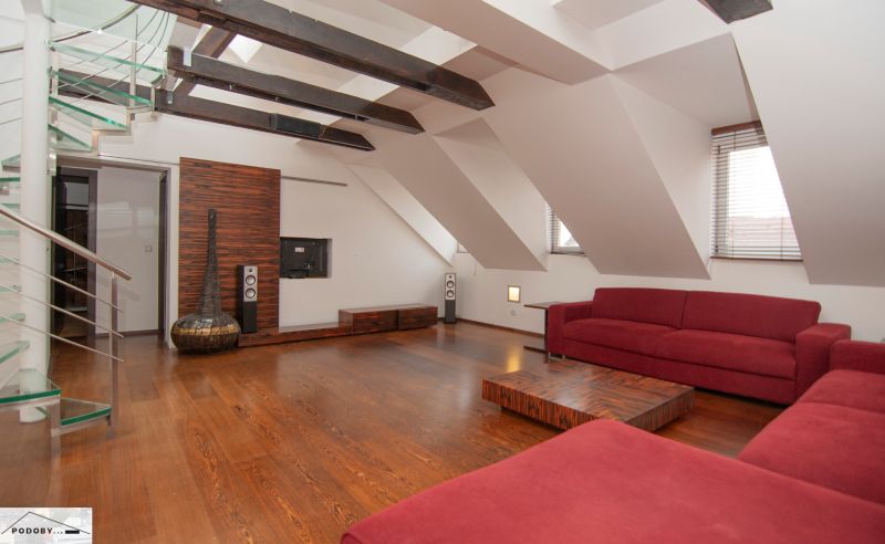 Loft living space in a 3-room apartment with a red sofa and a wooden decor floor.