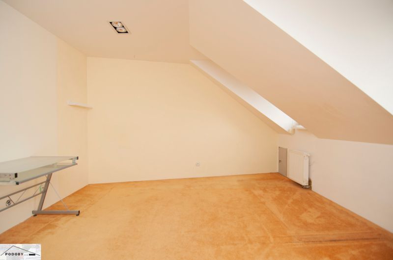 An attic room with a desk and a radiator in a 3-room apartment.