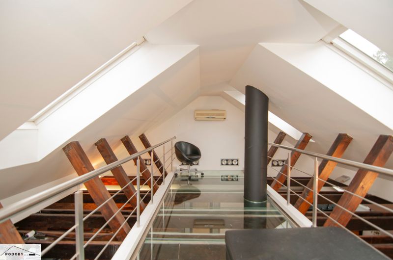 An attic space with a glass floor, an armchair, and air conditioning in a 3-room apartment.