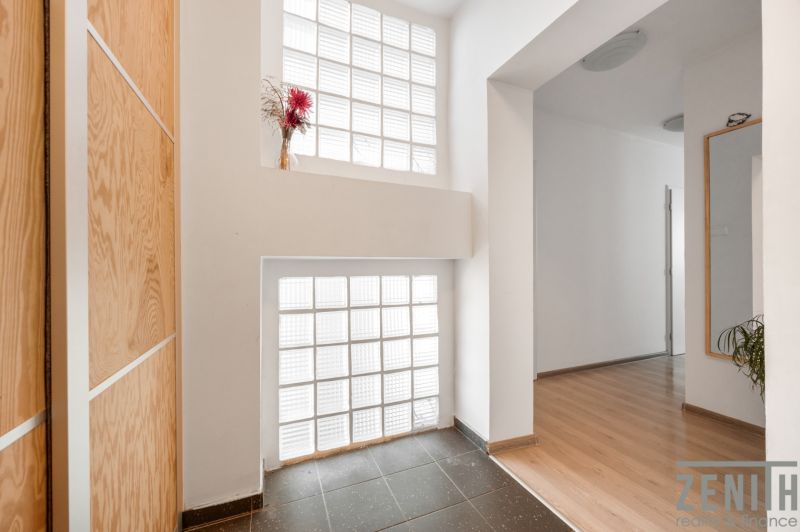 Entrance hallway with wood-patterned flooring and a skylight in a 2-room apartment.