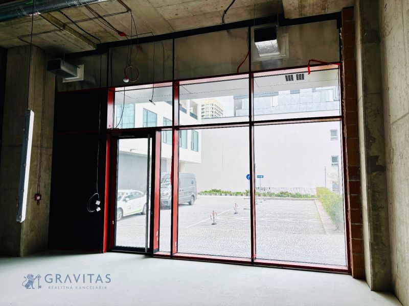 Commercial spaces with large glass doors and raw concrete walls.
