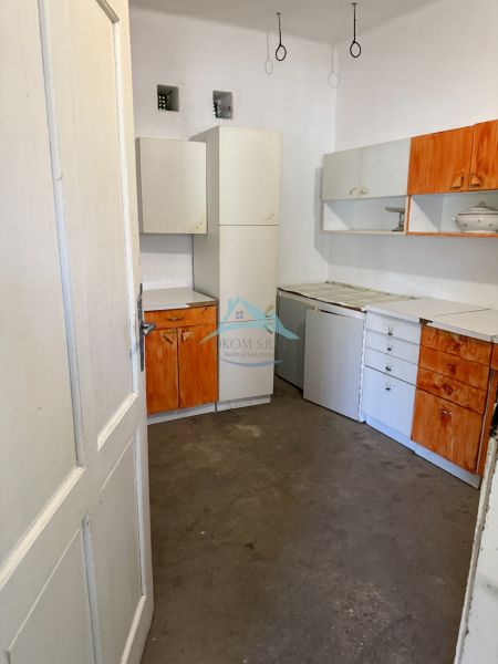 A kitchen in a family house with white and orange cabinets.