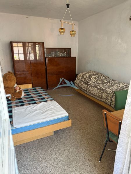 A room with two beds and a cabinet in a family house.