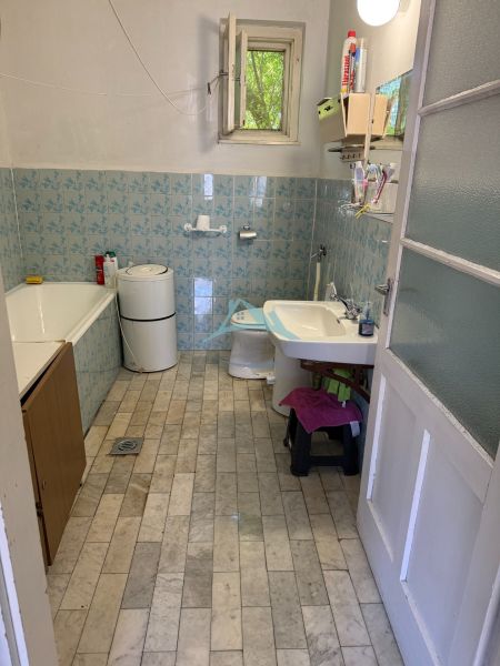The bathroom in the family house has tiled walls and flooring.