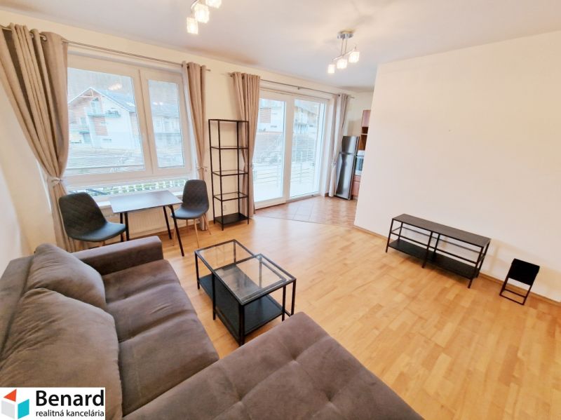 A bright living room with a sofa, a table, and a wooden decor floor in a 3-room apartment.