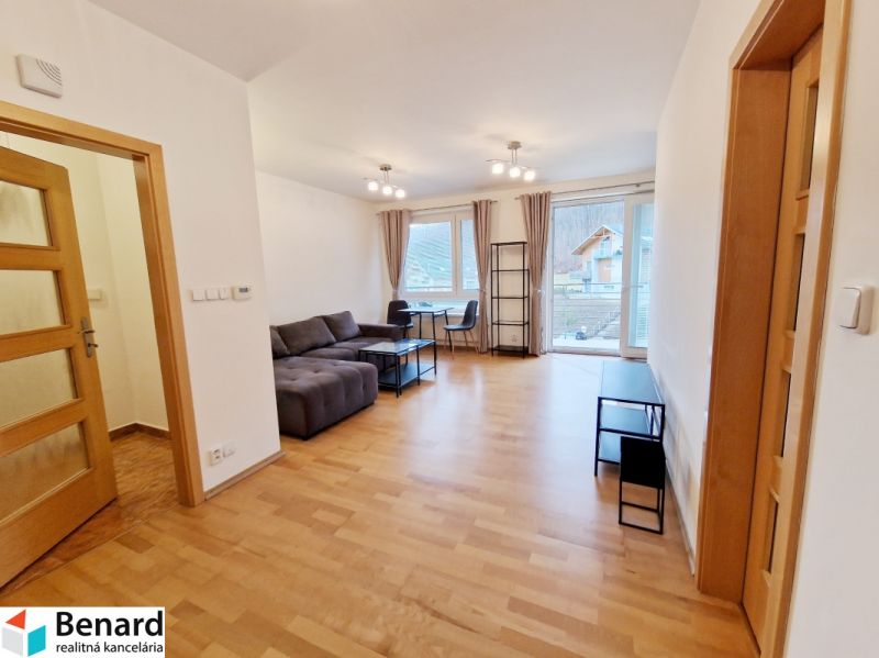 Living room in a three-room apartment with a sofa and a wooden decor floor.
