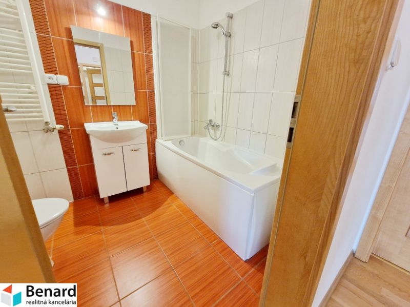 Bathroom in a 3-room apartment with a bathtub and a sink, floor with wood decor.