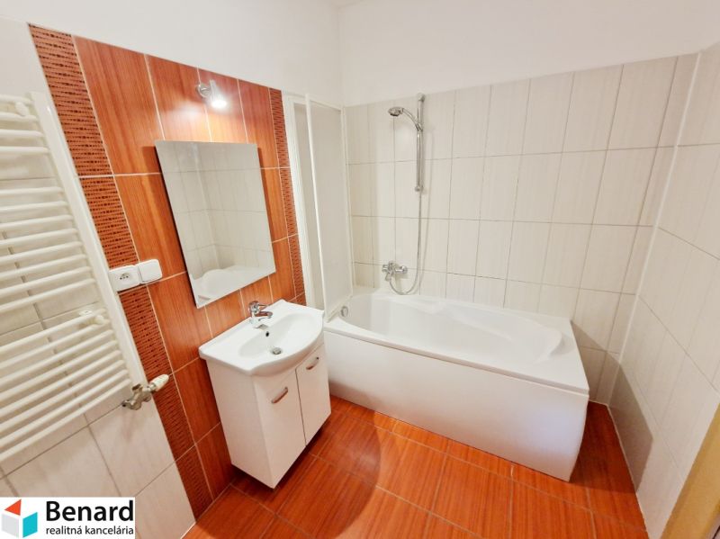 Bathroom in a 3-room apartment with a bathtub and orange tiles.