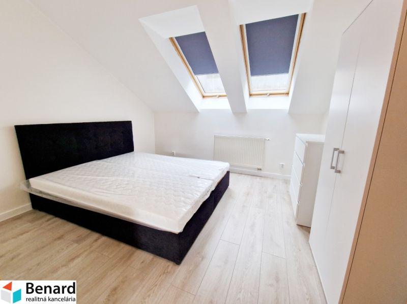 A bright room with a bed and built-in wardrobes in a three-room apartment.