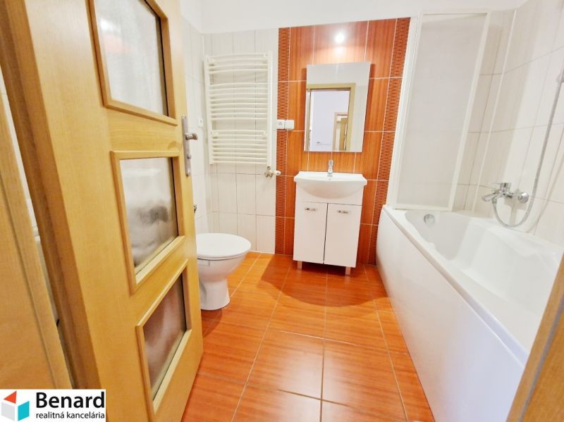 A bathroom in a 3-room apartment with a bathtub, sink, and orange tiles.