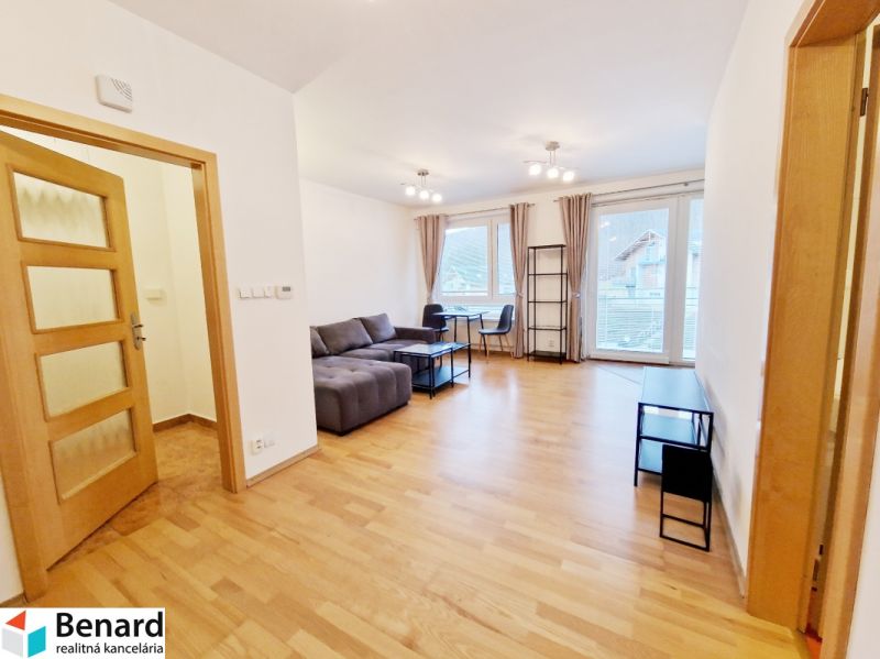 Living room in a three-room apartment with a wooden decor floor and a sofa.