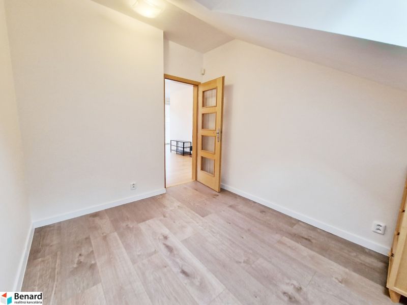 A room in a 3-room apartment with a wooden decor floor and light walls.