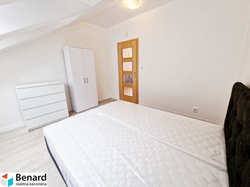 Bedroom with a bed, wardrobe, and wooden decor flooring in a 3-room apartment.