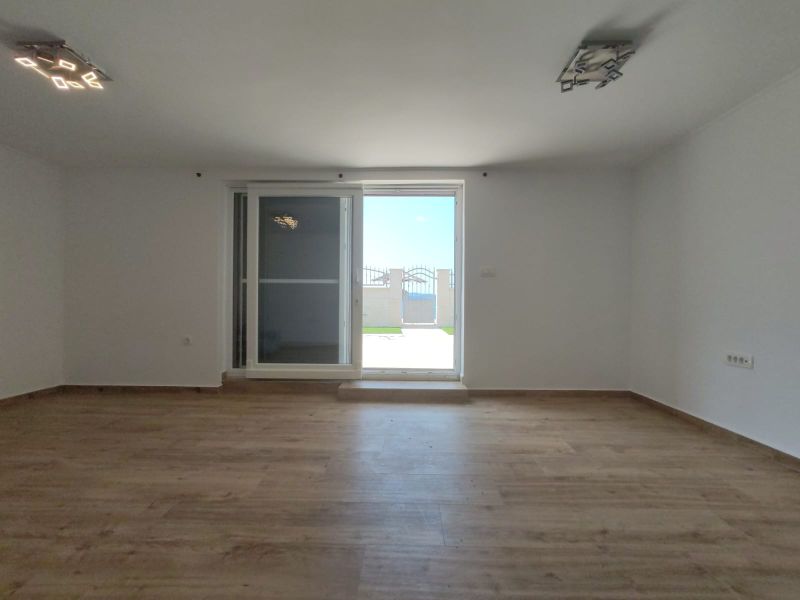 A room with a wooden floor decor and balcony doors in a family house.