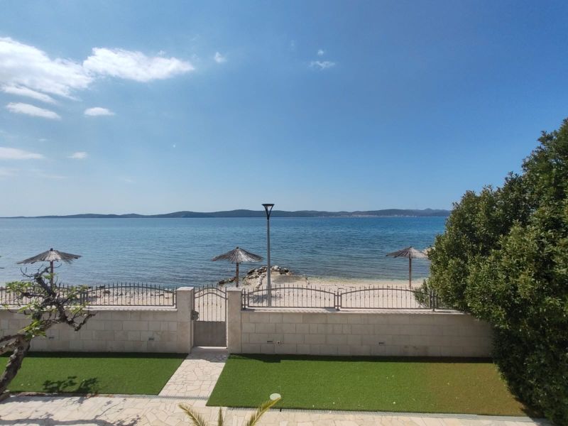 Sea view and terrace at a family house in Bibinje with beach umbrellas.