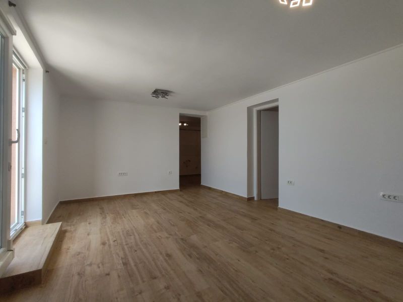 A large bright room in a family house with a wooden decor floor.