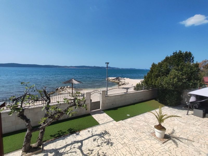 A family house in Bibinje offers a sea view with a stone terrace and garden greenery.