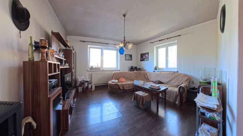 Living room in a family house with a dark floor and a sofa set.