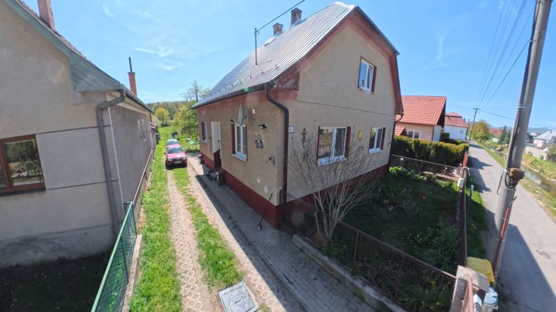 A family house in Svinná with a car on the driveway and a well-maintained garden.