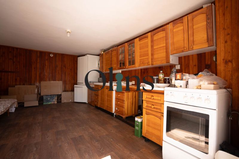 A kitchen in a family house with wooden cabinets and a floor with a wooden decor.