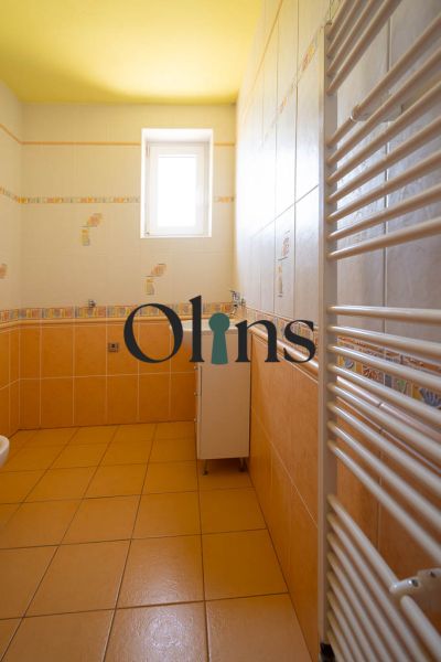 A bathroom in a family house with yellow walls and a white radiator.