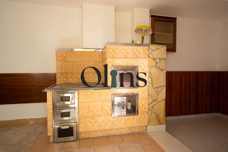 Tiled stove in a family house with ceramic cladding and wood decor on the walls.
