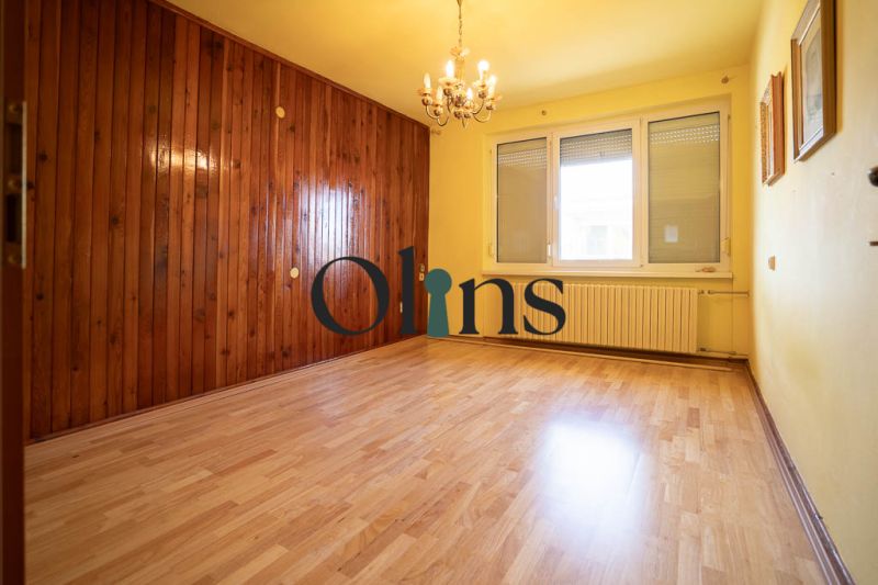 A room with wooden paneling and a floor with a wooden decor in a family house.