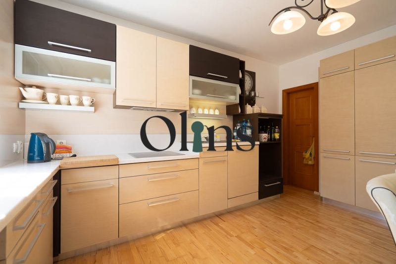 A kitchen in a family house with a wooden decor floor and light-colored furniture.