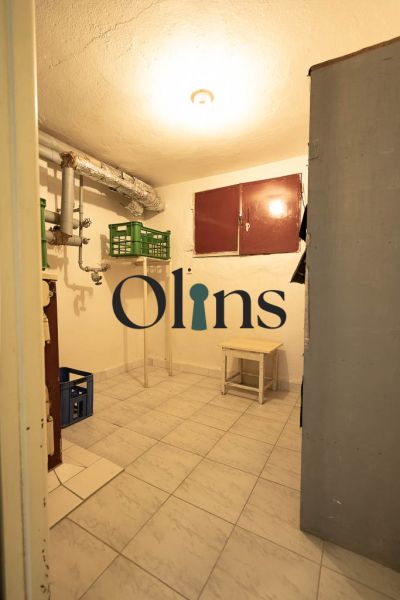A practical basement in a family house with a tiled floor, small furniture, and piping.