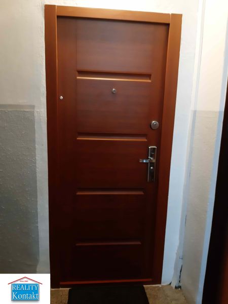 Brown entrance door in a 2-room apartment with security fittings.