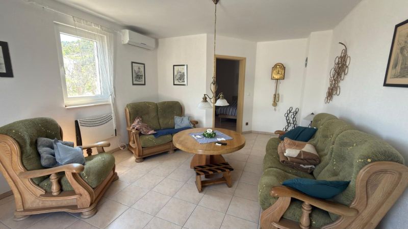 Living room in a family house with a sofa and wooden furniture.