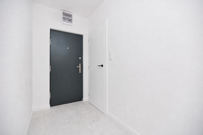 Entrance hallway with gray doors and white walls in a 3-room apartment.