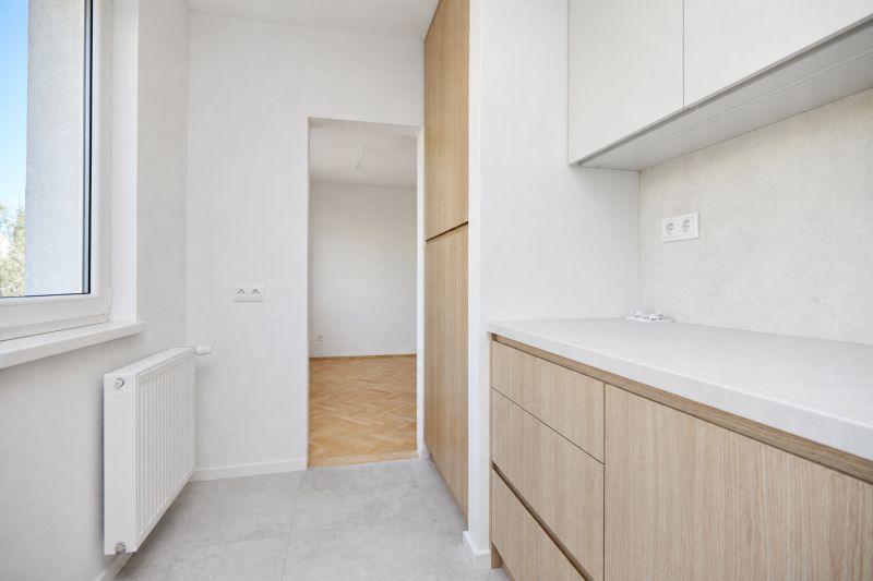 A kitchen with cabinets and a view of the floor with a wooden decor in a 3-room apartment.