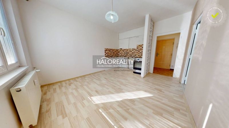 Kitchen in a studio apartment with a wooden decor floor and ceramic tiles.